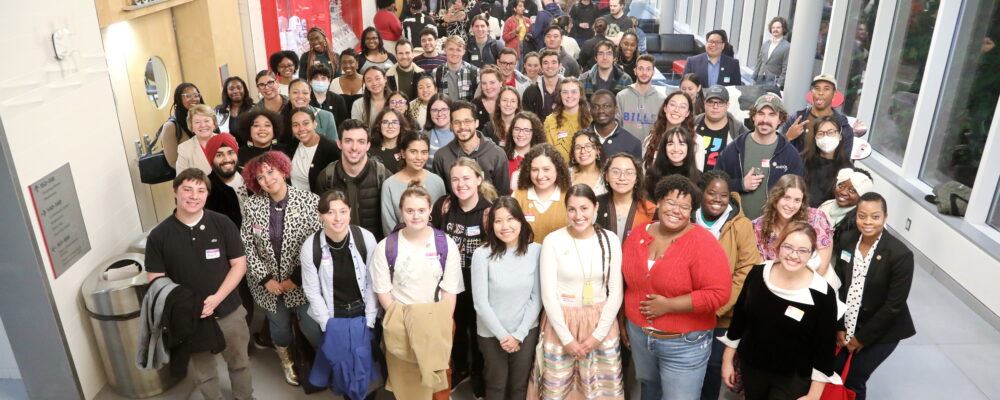 Group of people standing together in a foyer.